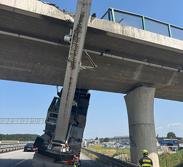 Jeřáb se ramenem zasekl do mostu na dálnici. Řidič lezl z kabiny po žebříku